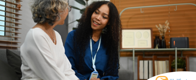 A caregiver patiently and kindly sits down and talks with a senior client, setting a good example for caregivers when it comes to communication.