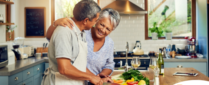 A senior couple enjoys cooking a healthy meal together, representing National Nutrition Month.