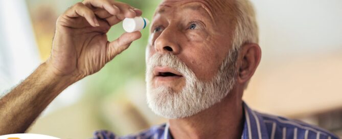 An older man uses eye drops as part of a good care routine to maintain his vision health.
